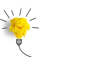 Crumpled yellow paper forming a light bulb with radiating lines on a white background—symbolizing a bright idea.
