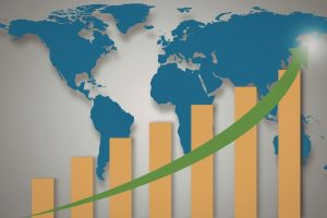 World map background with orange rising bars and a green upward arrow showing global growth.