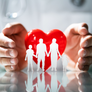 Hands shield a red heart containing a white silhouette of a family, symbolizing health and protection of loved ones.
